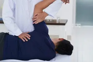 The doctor giving back pain treatment for patient The doctor giving back pain treatment for patient