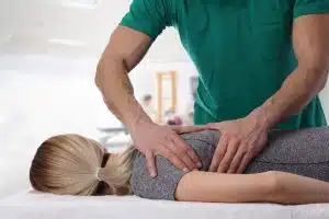 male chiropractor adjusting a female patient's back