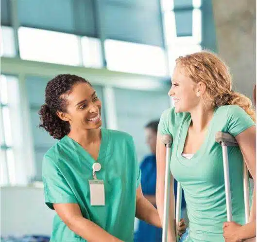 A female nurse assisting the lady having a post-surgery rehabilitation