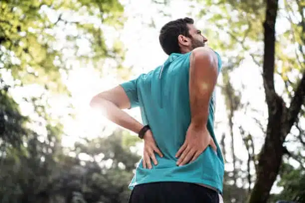 Man feeling of chronic back pain at the park
