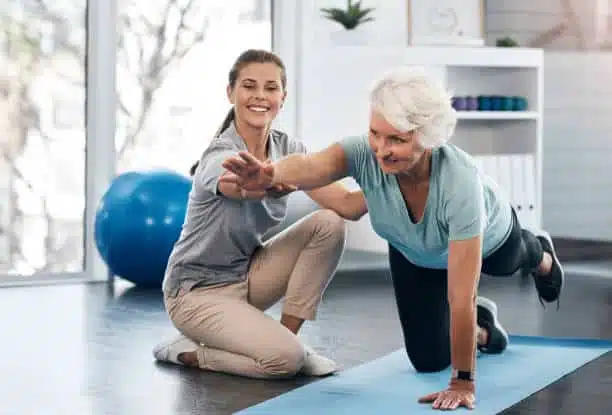 Physiotherapist helping a senior patient with his physical therapy treatment.